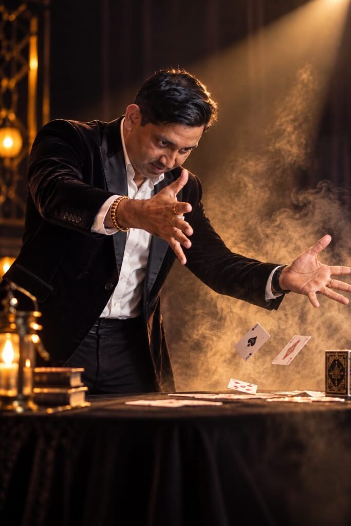 Vikram Singh making playing cards float above a table in golden stage light